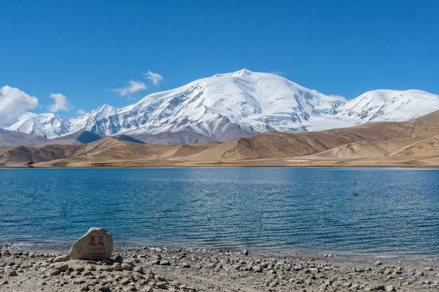 Karakul Lake on the Pamir Plateau with snow mountains and open landscape Karakul Lake on the Pamir Plateau with snow mountains and open landscape