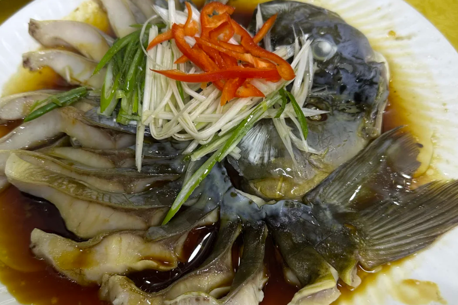 Xinjiang grilled cold-water fish cubes with chili seasoning served in traditional restaurant setting
