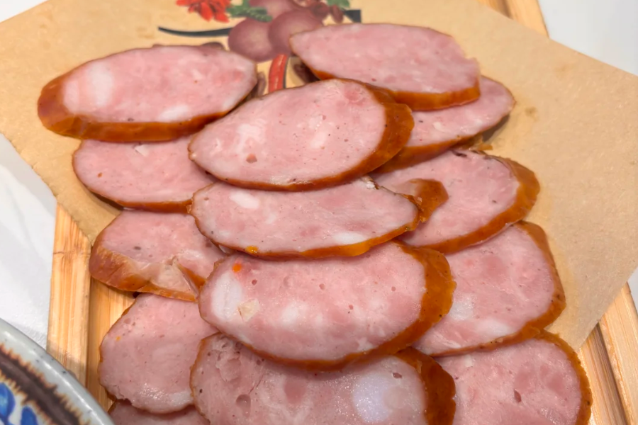 Russian sausage street food market in Xinjiang with kolbasa display and travelers choosing cured meat products Russian sausage street food market in Xinjiang with kolbasa display and travelers choosing cured meat products